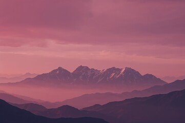 Stunning mountain range at dawn bathed in beautiful pink light creates a serene and peaceful scene