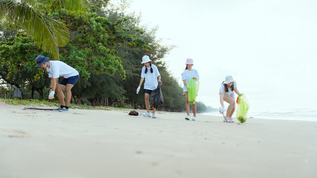 Group family on summer holiday vacation. Parents teaching children kid picking up plastic bottle and garbage on the beach. Environment protection volunteer and waste pollution concept