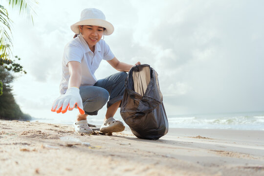 Community volunteers clean beach, collecting trash to protect the environment and wildlife at a coastal location - Powered by Adobe