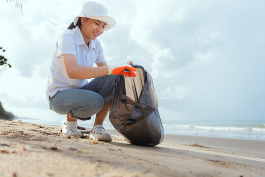 Community volunteers clean beach, collecting trash to protect the environment and wildlife at a coastal location