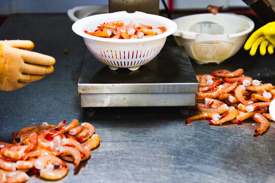 Raw shrimp being weighed and processed in a seafood plant in Alabama