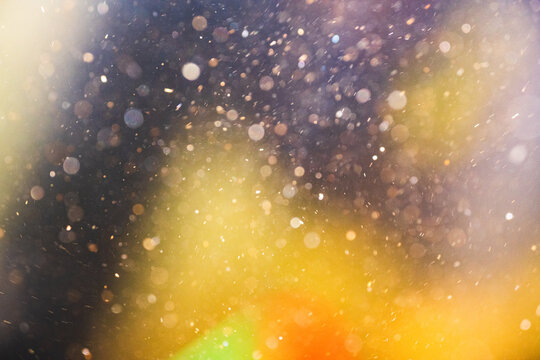 An abstract shot of bubbles and golden color moving underwater with sun shining in