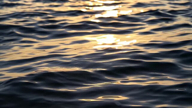 Serene cinematic 4K slow motion footage of calm ocean waves reflecting golden evening sunlight creating soft ripples peaceful shimmering water surface evoking tranquility relaxation meditative