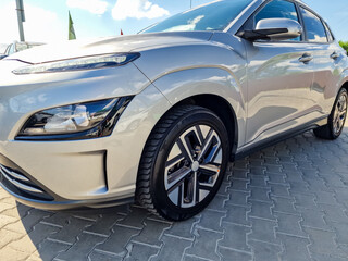 Naklejka premium A sleek silver car with a contemporary design and gleaming alloy wheels is parked elegantly in the driveway, showcasing a blend of elegance and innovative automotive style that captivates the eye