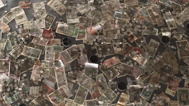 Old banknotes and coins scattered across a surface creating a nostalgic scene filled with vintage currency textures and faded colors evoking history and antique charm