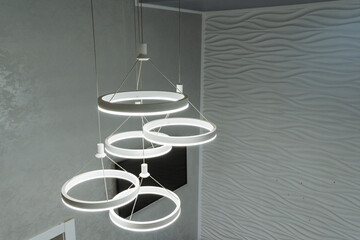 This modern LED chandelier showcases a stunning design with interconnected rings that perfectly complements and enhances the aesthetic of a contemporary living space, making it a stunning focal point