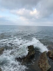 Rugged coastline with waves under the morning sun.
