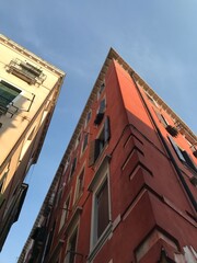Calm water reflecting charming Venetian architecture.
