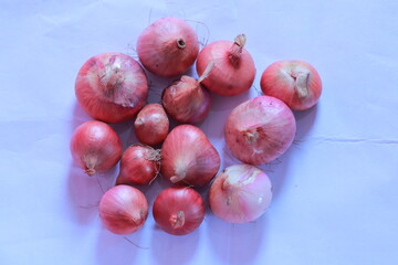 Fresh Red Onions: A collection of fresh, vibrant red onions, arranged in a close-up shot, providing a captivating display of natural produce for culinary and nutritional endeavors.