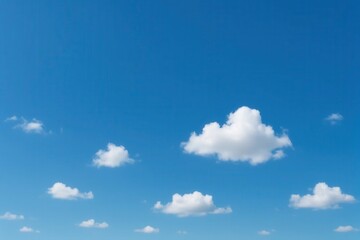 Fototapeta premium A serene expanse of blue sky dotted with fluffy white clouds, symbolizing tranquility and limitless possibilities