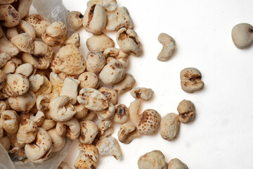 Puffed corn snack scattered beside a plastic bag isolated on white background expressing casual indulgence childhood nostalgia and simple street market culture.
