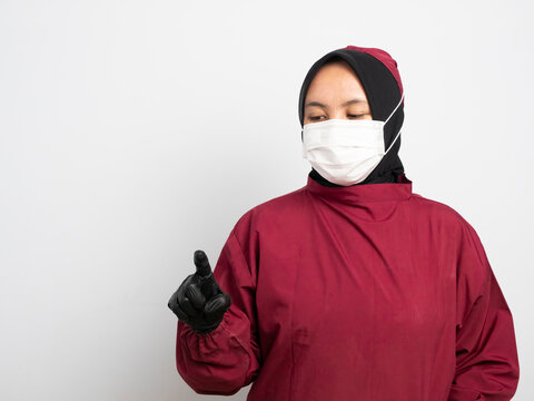 Close up of female Doctor pointing with finger on virtual touchscreen in medical futuristic interface. Doctor, young Asian Muslim nurse gives index finger as a gesture of pointing at something.