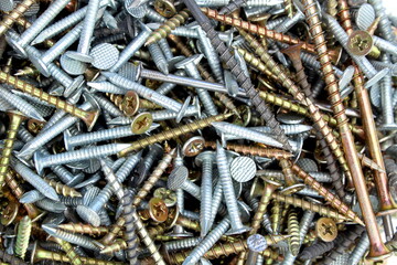 Texture of various nails and screws in a pile.