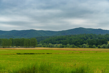 beautiful spring landscape, view to fields and village, in the distance Carpathian mountains