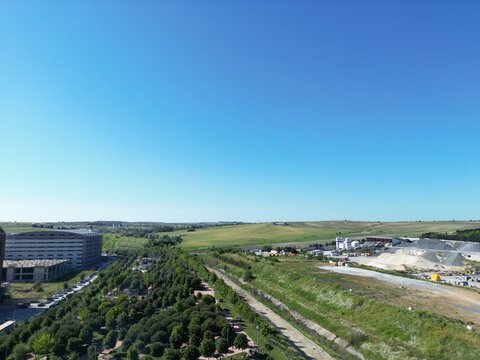Aerial view of a contrasting landscape where urban development meets open fields under a clear blue sky, Arnavutk&Atilde;&para;y, &Auml;&deg;stanbul, T&Atilde;&frac14;rkiye.