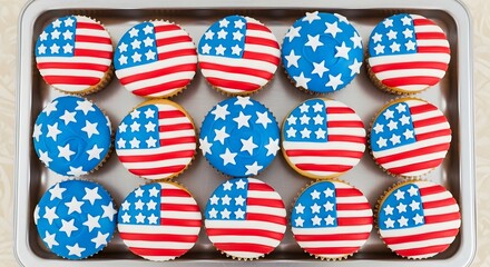 A metal baking sheet filled with American flag-themed cupcakes, decorated with icing.