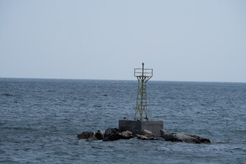 Marine warning buoy with a built-in light system floating in the sea, used to guide ships and prevent collisions or shipwrecks