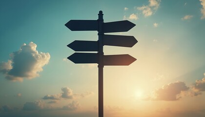 Blank directional road signs with black metal arrows against tranquil blue sky. Signpost offers multiple empty choices for guidance, decision-making, travel. Warm toned colors, clouds create
