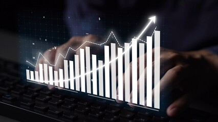 Hands typing on a keyboard with an overlay of a digital growth graph, illustrating data analysis and trends in a modern office environment. Copula