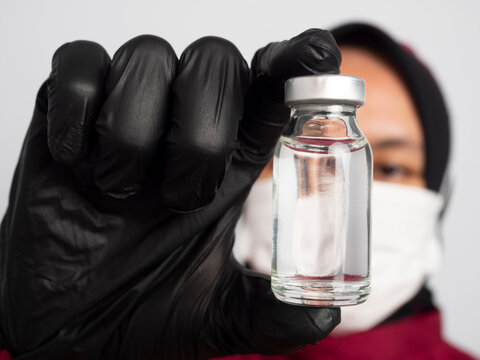 Doctor, nurse, and female scientist holding a blank vial on an isolated background. Blank medical vial mockup concept for pharmaceutical, vitamin, and research companies.