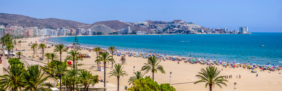 Cullera Bay beach on the Mediterranean Sea, on a sunny day with many umbrellas