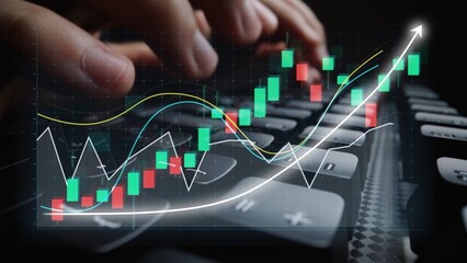 A close-up view of hands typing on a keyboard with an overlay of stock market charts and graphs illustrating growth, investment data, and financial analysis. Copula