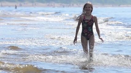 Beautiful teenage girl running on water on a summer sea beach and having fun. Slow motion. - Powered by Adobe