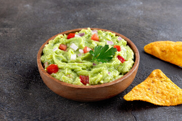 Mexican guacamole dip with ripe hass avocado, tomatoes, jalapenos, crispy tortilla chips. 