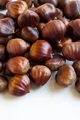 New harvest, ripe shelled chestnuts, designed on a white surface