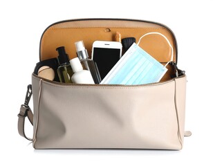 Beige bag filled with beauty items and a mask