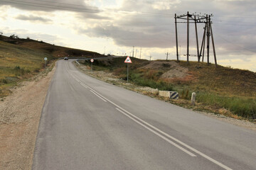 Asphalt road passing through mountainous terrain. Section of road with sharp turns