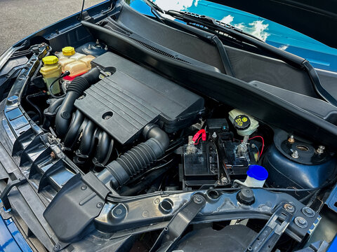 A closeup image of a car engine compartment highlights its essential components and wiring, showcasing the complexity of automotive engineering and related repairs and maintenance - Powered by Adobe
