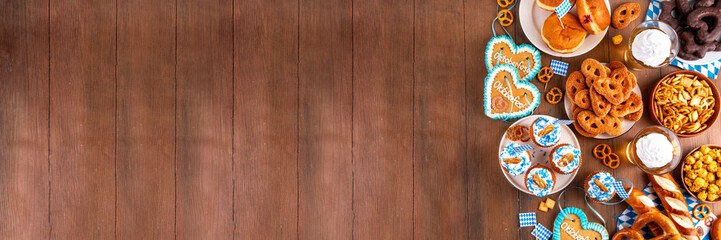 Oktoberfest festive food, with various snacks, sweets, desserts, pretzels, beer jelly, gingerbread cookies hearts, salted crackers, popcorn, jam donuts, cupcakes. Oktoberfest brunch menu background