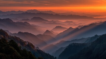 Obraz premium Serene Sunrise Over Misty Mountains in Vibrant Orange and Blue Hues