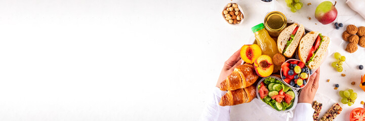 Preparation or ready made brunch box with sandwiches, salad, croissant, cookie and fruit for...