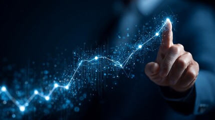 Businessman's hand points upward at digital growing chart in business/office environment