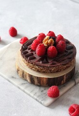 Homemade Vegan and gluten free Chocolate Ganaches Cake, topped with rasberries on a white background