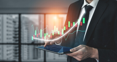 A professional businessman engages with stock market data on a tablet in a modern office, showing financial graphs and trends for informed decision-making. Impute