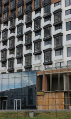 Fototapeta premium Coloured metal scaffolding on a construction site during finishing works on glazing a new residential building 
