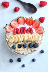Vegan Porridge bowl with fresh fruits on a white plate and white background