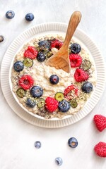 Vegan Porridge bowl with fresh fruits on a white plate and white background