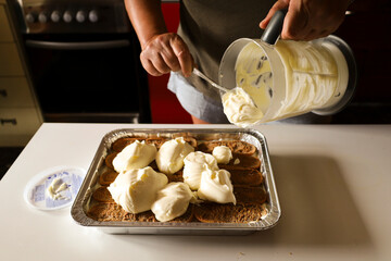Woman making Tiramisu dessert in the kitchen