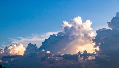Sunlit Cumulus Cloud Against Blue Sky with Wispy Background Clouds