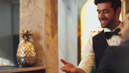 Good looking smiling smart bartender friendly conversation talking VIP customer at beverage counter...