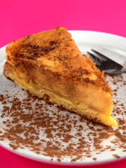 Delicious slice of apple cake with cinnamon dusting on a white plate