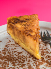Delicious slice of apple cake with cinnamon dusting on a white plate