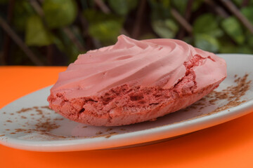 Close-up of a delectable pink merinque on a white plate