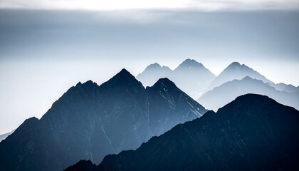 Misty Mountain Peaks: Layered Silhouettes in Blue-Gray Hues