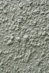Green painted textured wall with rough surface