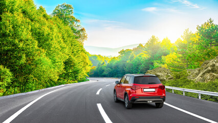 Red car driving on the panoramic road landscape in summer. Nature landscape on highway for summer vacation travel. Forest road scene on beautiful nature panorama trip in Europe. Car drive on mountain.